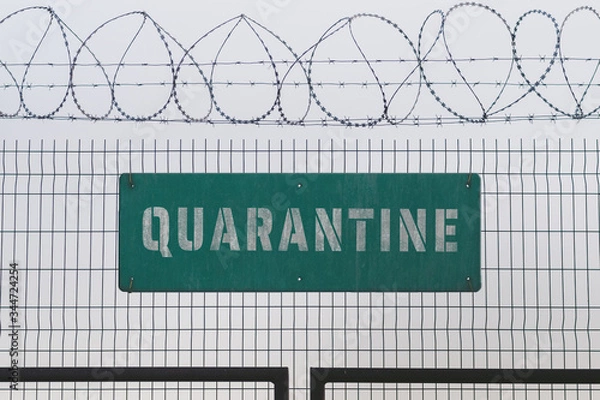 Obraz Quarantine sign on barbed wire fence, a digital composite. Tough lockdown measures restrict rights of people as well as ruin economics in many countries during the coronavirus (COVID-19) epidemic.