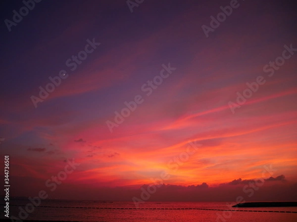 Fototapeta 夕暮れに赤く染まる空と海