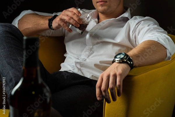 Obraz brutal man holds a glass of whiskey in his hands