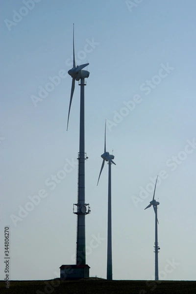 Fototapeta Wind turbines generating power on green field