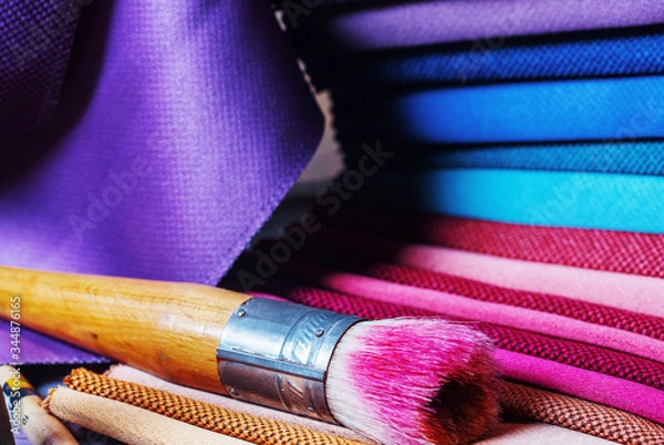 Fototapeta colorfull textile lies on a colorfull palette of the artist.Colored brushes and fabrics.