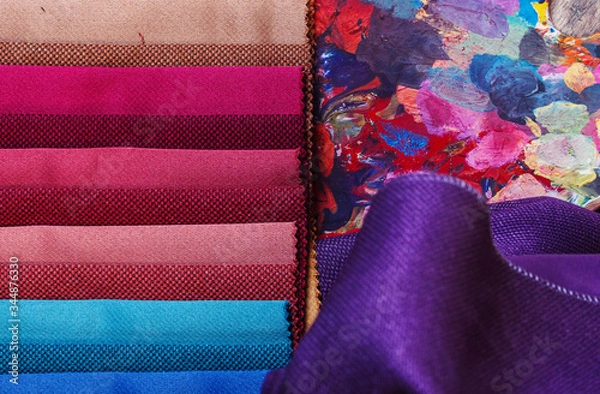 Fototapeta colorfull textile lies on a colorfull palette of the artist.Colored brushes and fabrics.