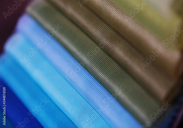 Fototapeta colorfull textile lies on a colorfull palette of the artist.Colored brushes and fabrics.