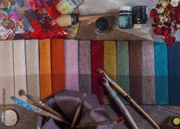 Fototapeta colorfull textile lies on a colorfull palette of the artist.Colored brushes and fabrics.