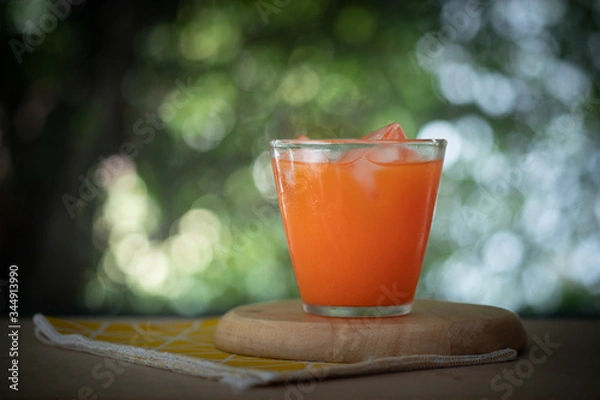 Fototapeta Fresh carrot juice in glass with ice