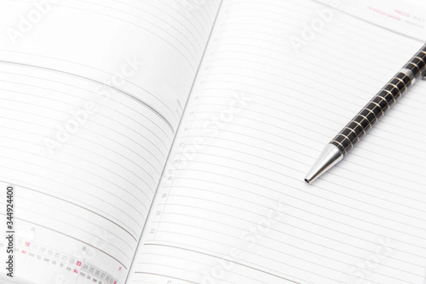 Obraz Open notebook with black pen on white background. Isolated on white