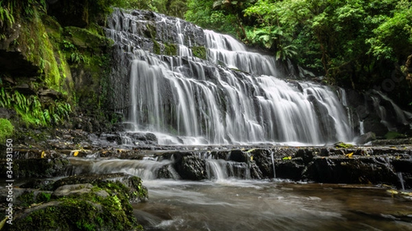 Fototapeta Beautiful cascade waterfall surrounded by forest. Shot made at Purakanui Falls in Catlins Forest Park, New Zealand