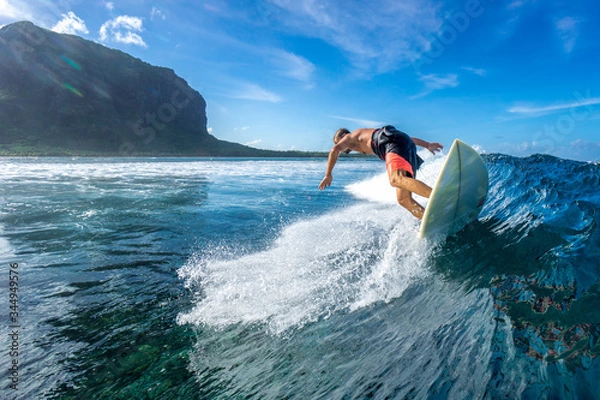 Fototapeta muscular surfer riding on big waves on the Indian Ocean island of Mauritius