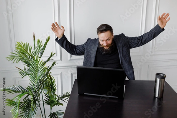Obraz Portrait of amazed man with laptop computer over white background.