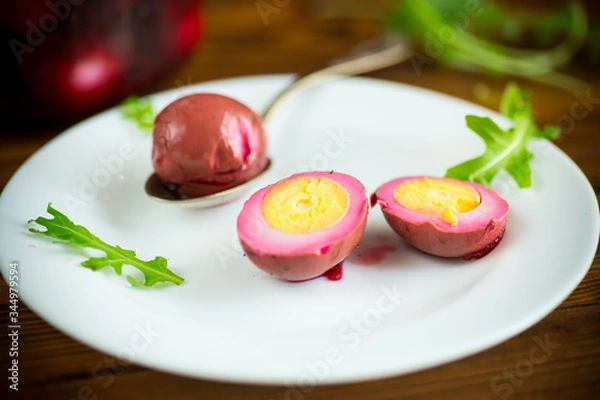 Obraz marinated chicken eggs in beetroot marinade in a plate