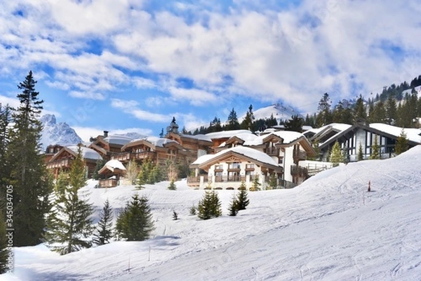 Obraz Courchevel ski resort in winter with it’s beautiful wooden chalets next to the ski slope.