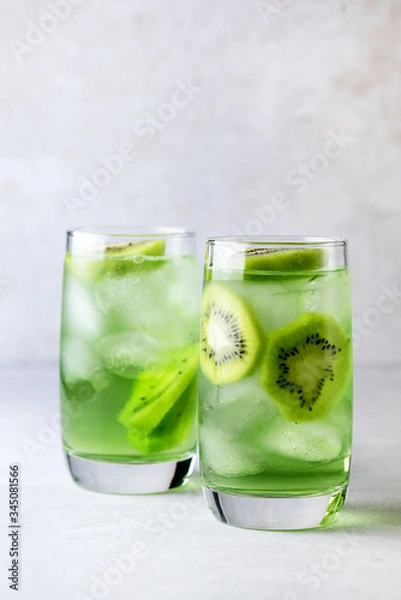 Fototapeta Glass of Refreshing Tropical Kiwi Lemonade With Ice on Light Gray Background Tasty Summer Beverage Healthy Detox Diet Drink Vertical