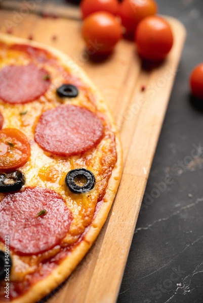 Obraz Fresh pepperoni pizza served on the rustic background. Selective focus. Shallow depth of field.