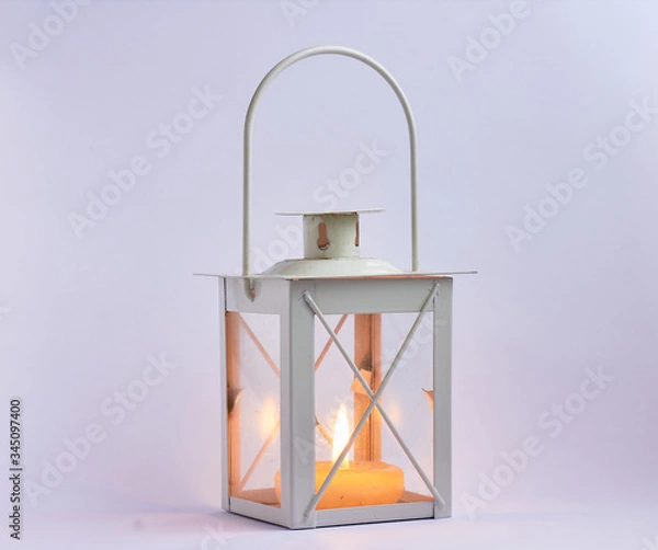 Fototapeta burning candle inside a lantern on white background