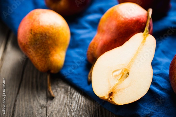 Fototapeta Fresh and ripe sliced pears on the rustic background. Selective focus. Shallow depth of field.