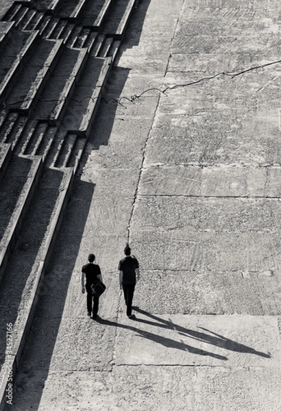 Obraz Two adults walking together with shadow