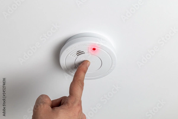 Fototapeta Testing home smoke alarm detector. Stay home safe. Home control and security.  Smoke detector
