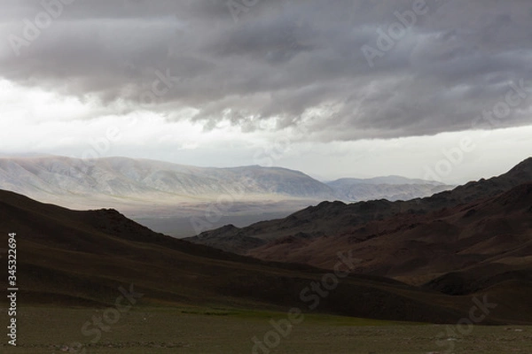 Obraz Dark mountain under a stormy evening dramatic cloudy sky. Altai, Mongolia