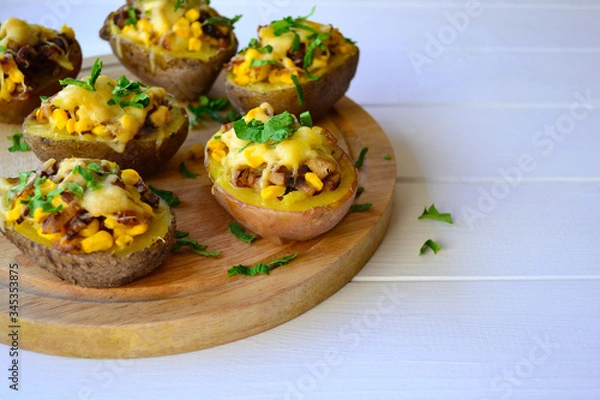 Fototapeta Stuffed baked potato with mushrooms, onion and corn on a white background.