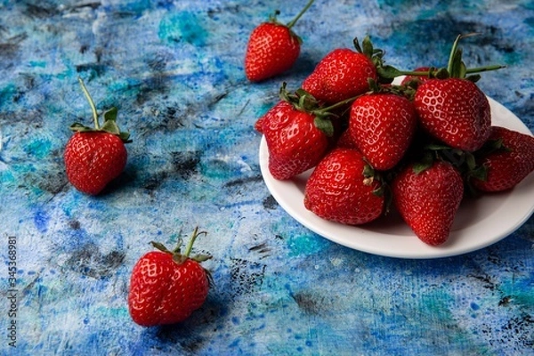 Obraz red strawberries on a blue background