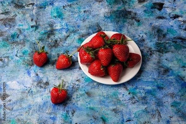 Obraz red strawberries on a blue background