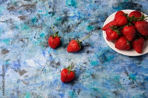 Obraz red strawberries on a blue background