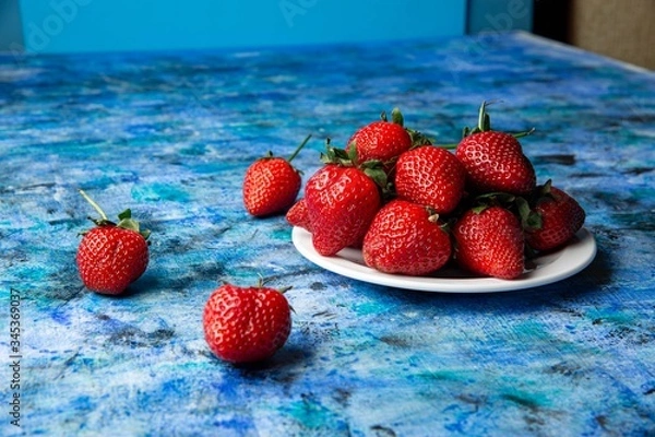Obraz red strawberries on a blue background