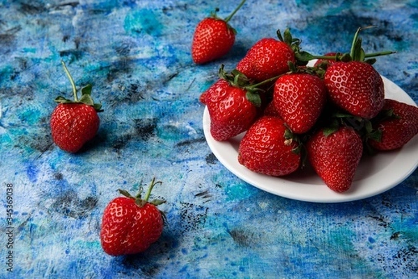 Obraz red strawberries on a blue background