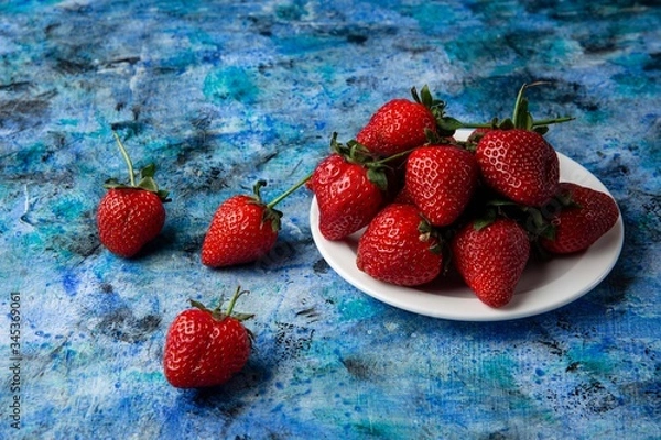 Obraz red strawberries on a blue background