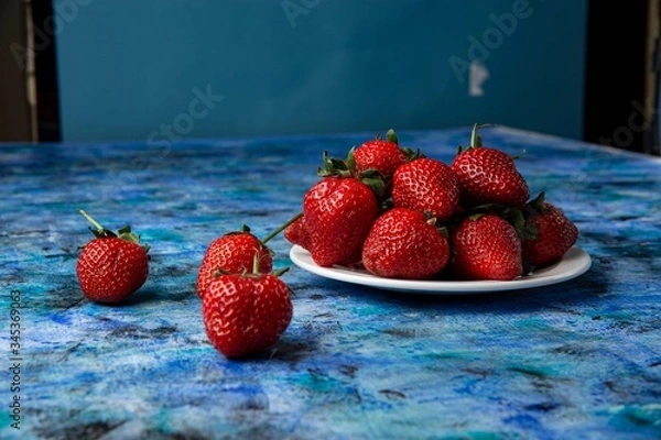 Obraz red strawberries on a blue background
