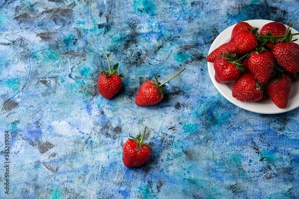 Obraz red strawberries on a blue background