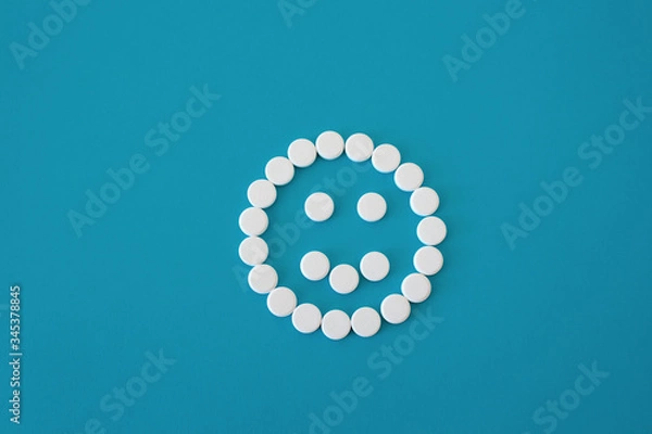 Fototapeta Pills positive smile on blue background, smile is centered , concept mood, isolated