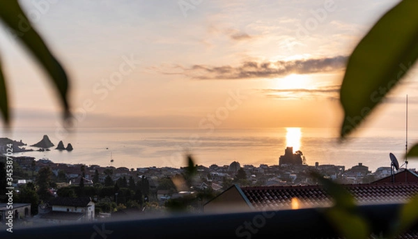 Fototapeta Landscape of the sunset of the Sicilian seashes, sea views with horizon and glimpse of the sunlit city, Faraglioni