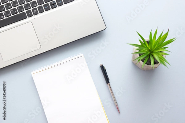 Obraz Blue desk office with laptop, smartphone and other work supplies with cup of coffee. Top view with copy space for input the text. Designer workspace on desk table essential elements on flat lay