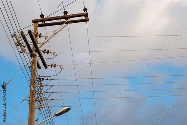 Fototapeta Electric wires wooden pole. Parallel and perpendicular lines.