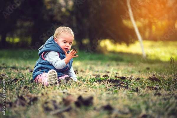 Obraz Toddler playing in grass and mud. Dirty hands, nature and immunity concept.