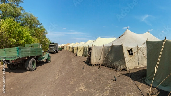 Fototapeta A big military World War II soviet tent camp with old trucks on a road