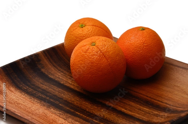 Fototapeta Oranges on a wooden plate