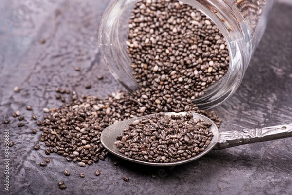 Fototapeta on a gray structure, top view, a pile of chia seeds, with spoon, close-up view
