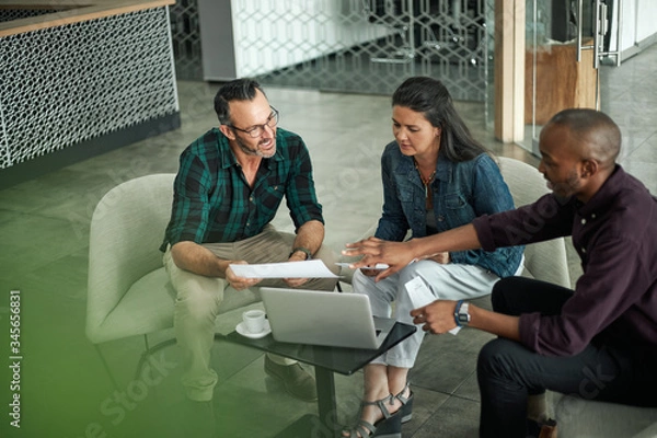Fototapeta Casual meeting of diverse business team analyzing financial data