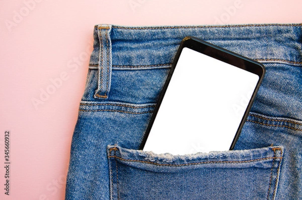 Fototapeta White screen smartphone in jeans pocket. Smartphone place for text. Smartphone in a pocket on a pink background.  Copy Space