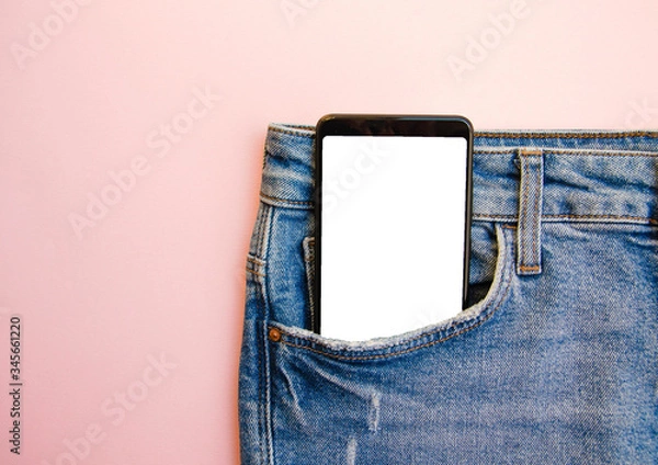 Fototapeta White screen smartphone in jeans pocket. Smartphone place for text. Smartphone in a pocket on a pink background.  Copy Space