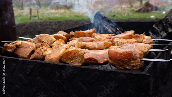 Fototapeta cooking pork skewers on the grill. meat with spices.