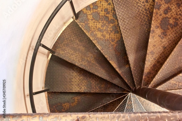 Fototapeta Metal spiral staircase in the old building