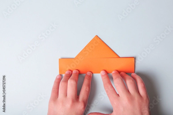 Fototapeta Step by step photo instruction. How to make origami paper boat. DIY for children. Children's art project craft for kids