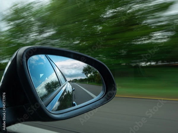 Fototapeta image of an exterior mirror while driving on the motorway