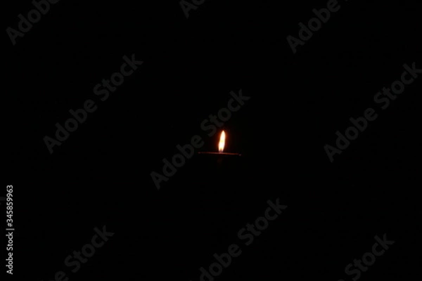 Obraz burning candle on black background