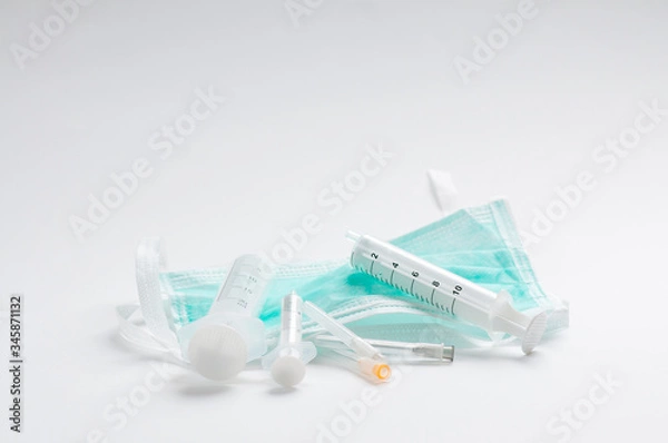 Obraz Green protective mmedical, surgical face masc COVID-19. on white background with syringes and needles