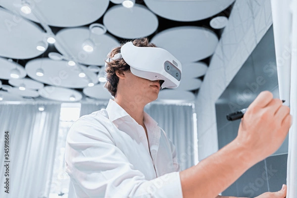 Obraz Man Wearing Virtual Reality Goggles in Modern Co-working Office Rehearsing his Speech at Presentation With Online Viewers. Social Distancing