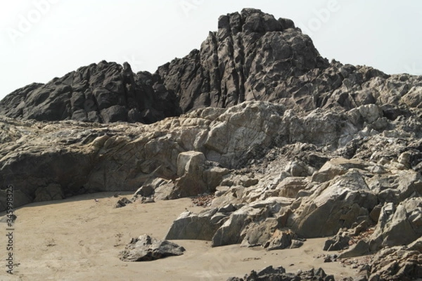 Fototapeta Rocks from volcanic rock on ocean beach